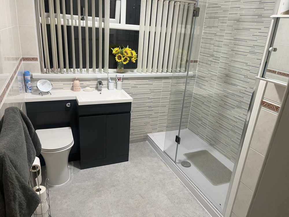 Finished bathroom with walk-in shower and dark vanity unit
